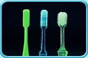 Photograph of several toothbrushes with their brush heads in rectangular shape.