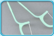 Photograph of two disposable dental floss holders.