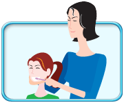 Photograph showing an adult standing behind a child with his hand supporting the child’s chin and brushing his teeth.