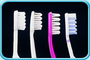 Photograph of several tooth brush heads in wavy or V-shape pattern.